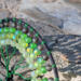 6 inch black yarn wrapped hoop cradles black and green wire tree of life, adorned with black and shades of green frosted glass beads. 